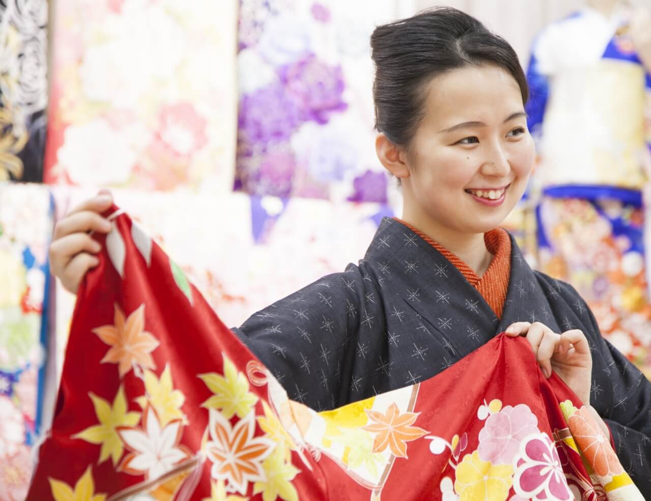 カラフルな布を持った着物姿の女性